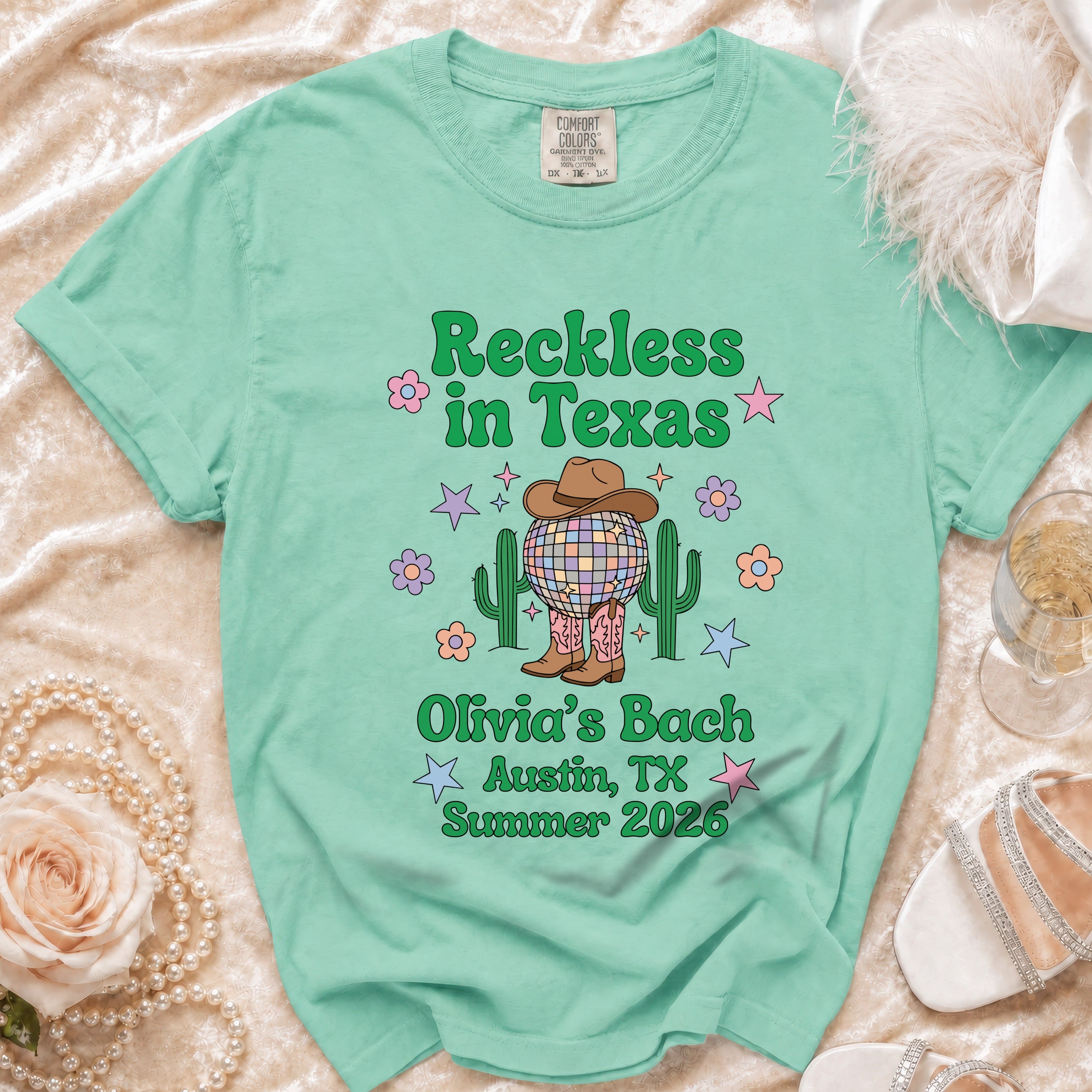 Mint green t-shirt with "Reckless in Texas" and "Olivia's Bach Austin, TX Summer 2026".
