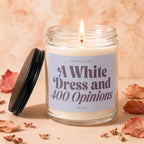 Candle with a lit wick and label reading "Smells Like A White Dress and 400 Opinions".