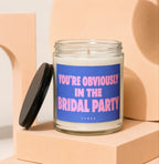 Candle with "YOU'RE OBVIOUSLY IN THE BRIDAL PARTY" text on a blue label and "VOWED" below.