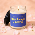 Candle with blue label that reads "Soft Launch: Boyfriend Hard Launch: Fiancé."