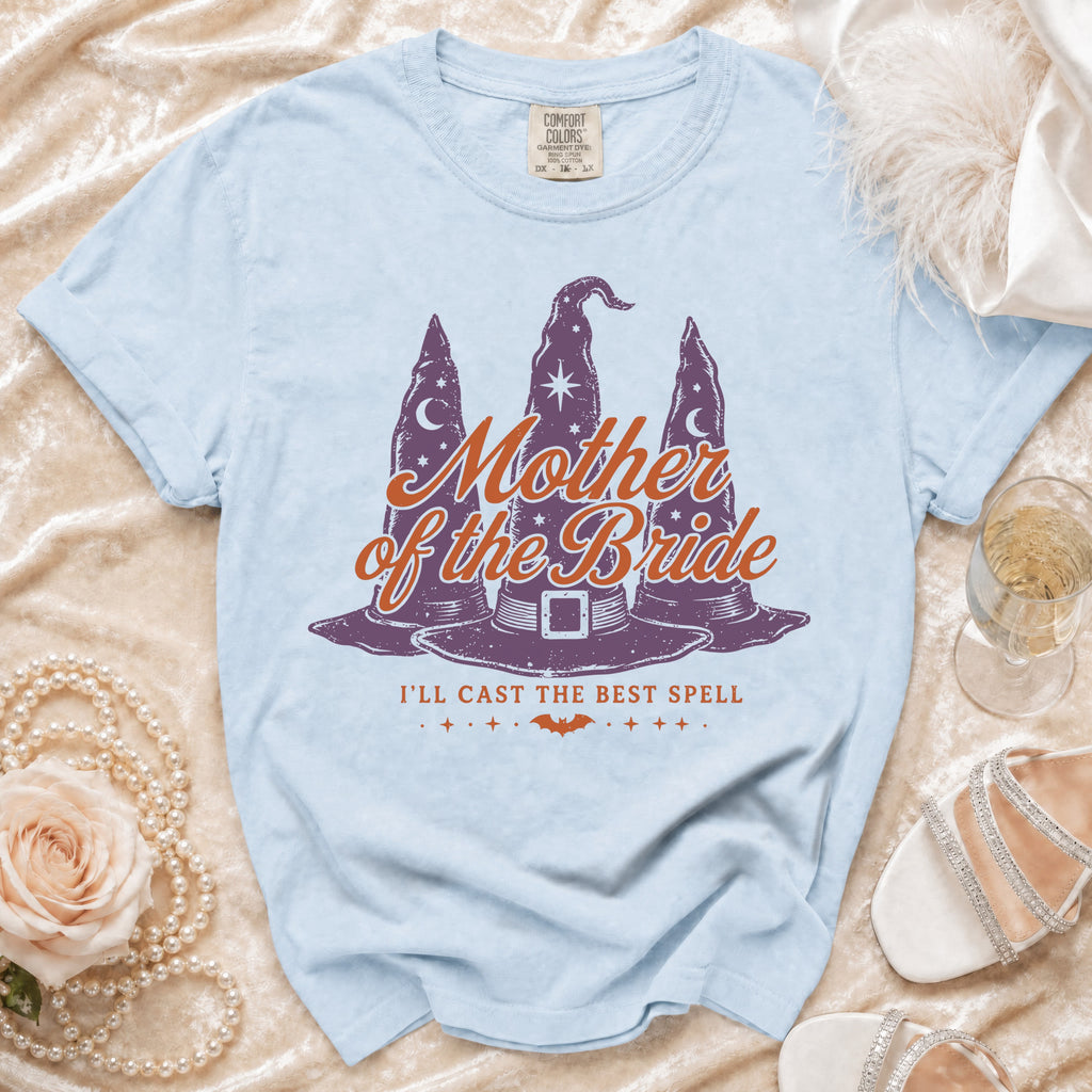 Light blue t-shirt with "Mother of the Bride I'll Cast the Best Spell" graphic.