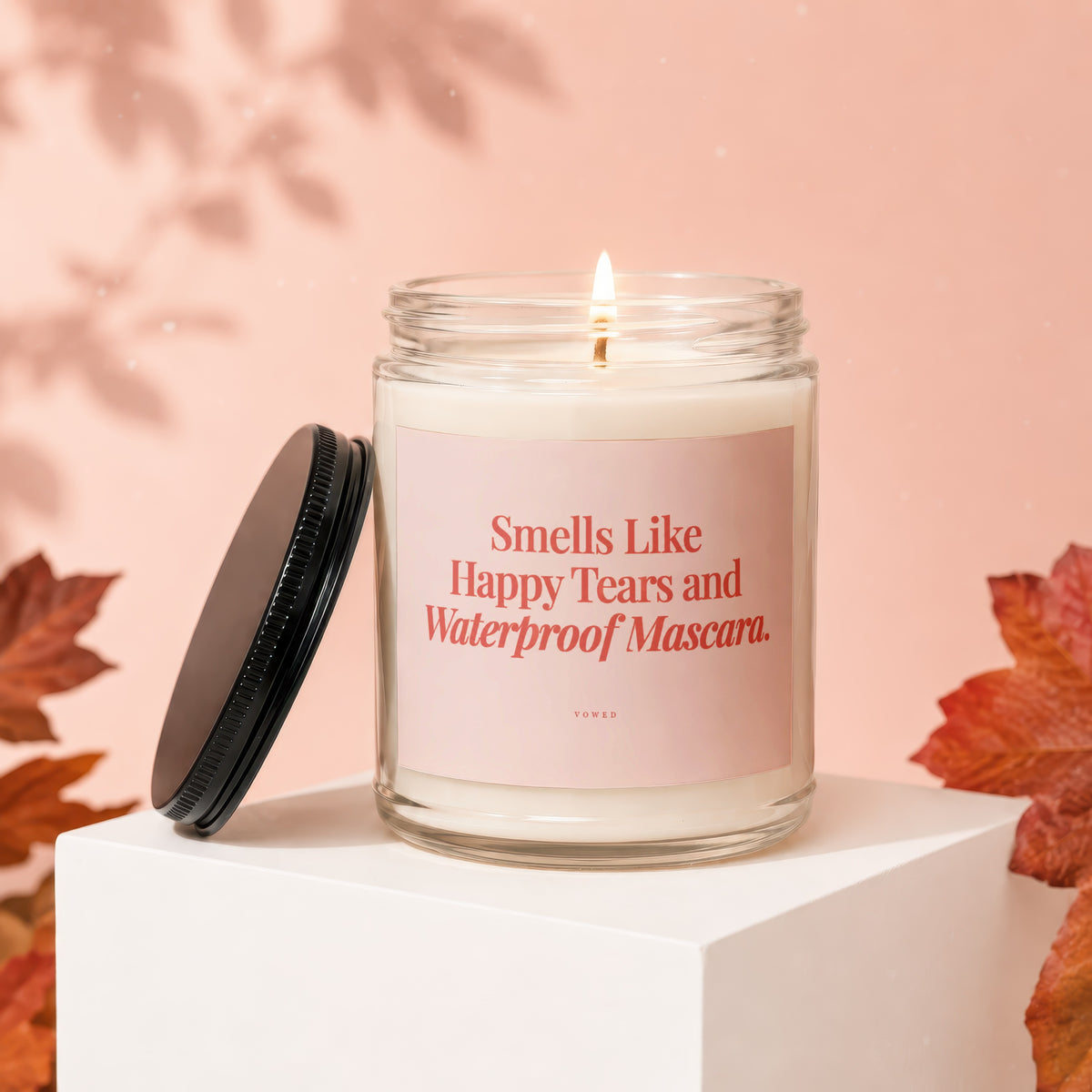 Candle with text "Smells Like Happy Tears and Waterproof Mascara."