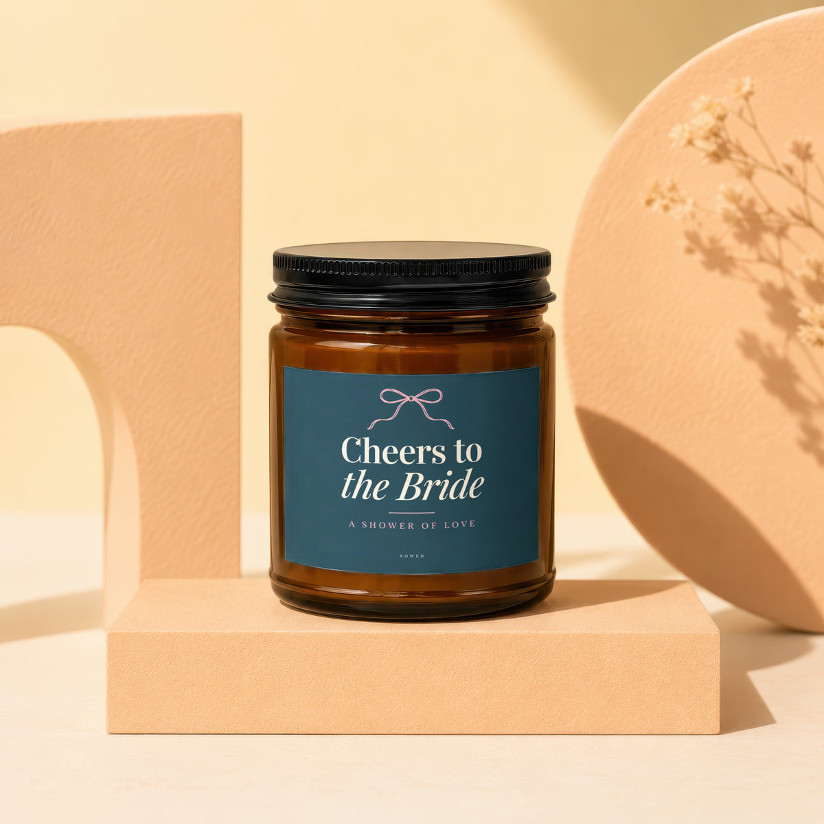 Amber candle with "Cheers to the Bride" label on a pedestal.