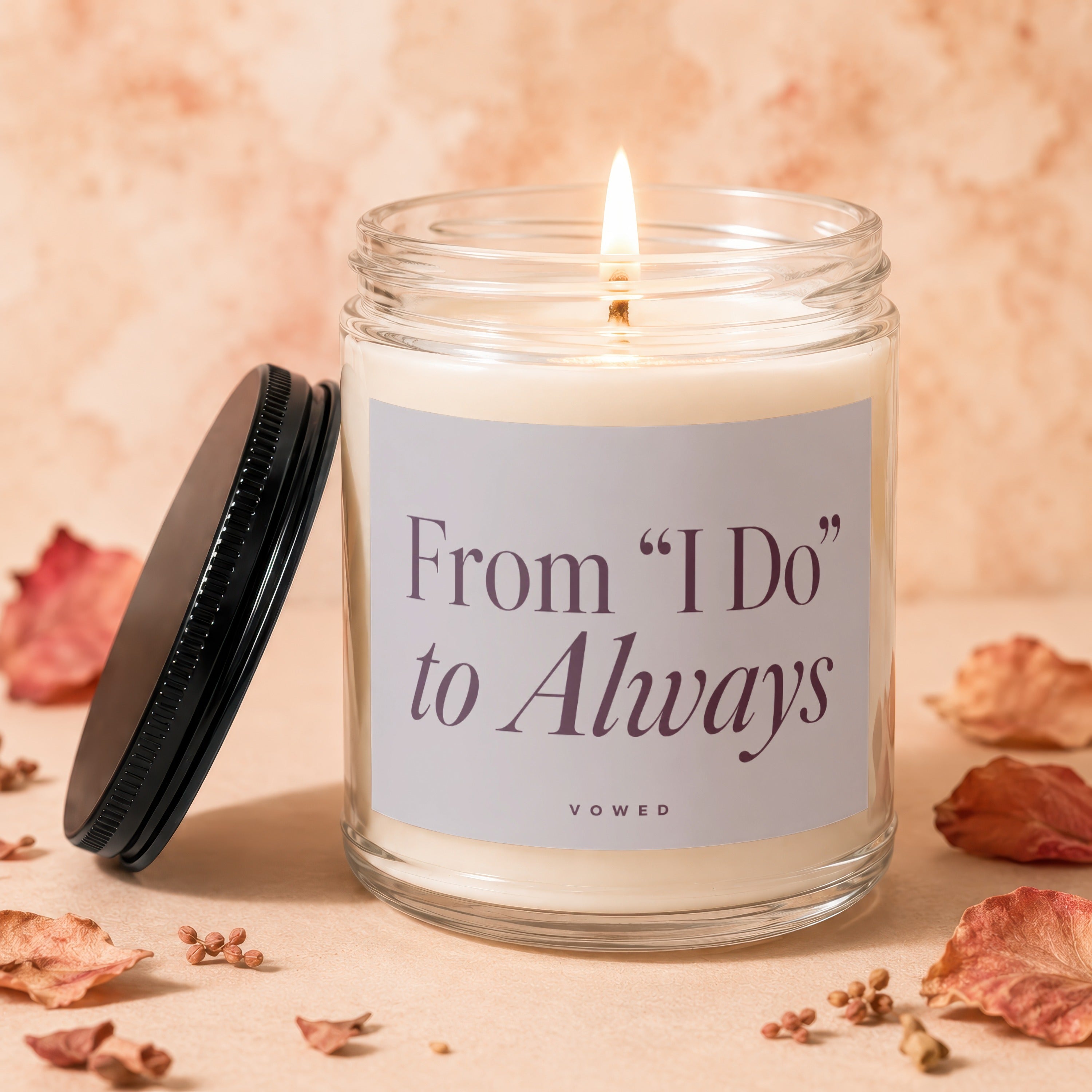 Glass candle with burning flame, lid off, reads "From 'I Do' to Always".