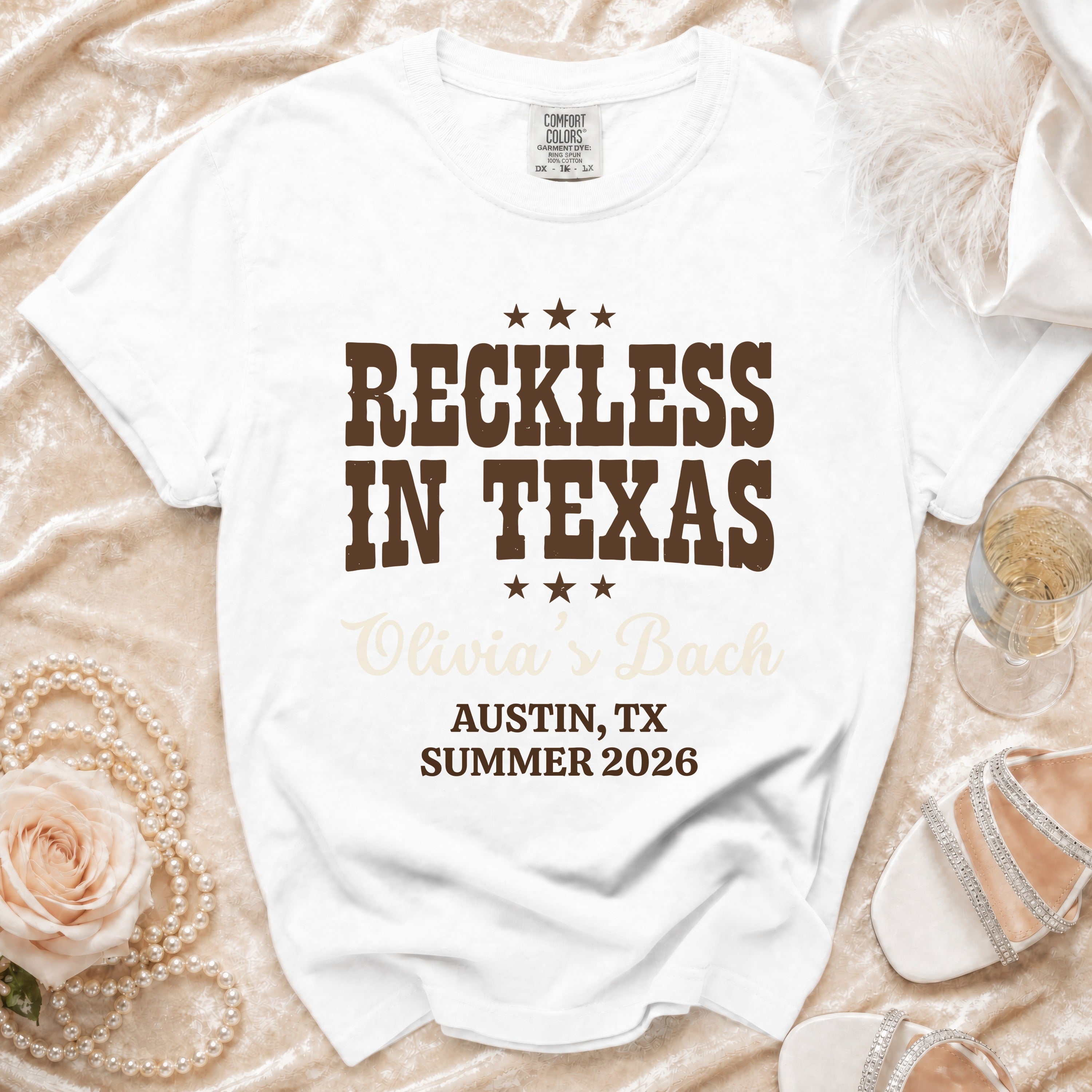 White t-shirt with "Reckless in Texas Olivia's Bach" text for Austin, TX Summer 2026.