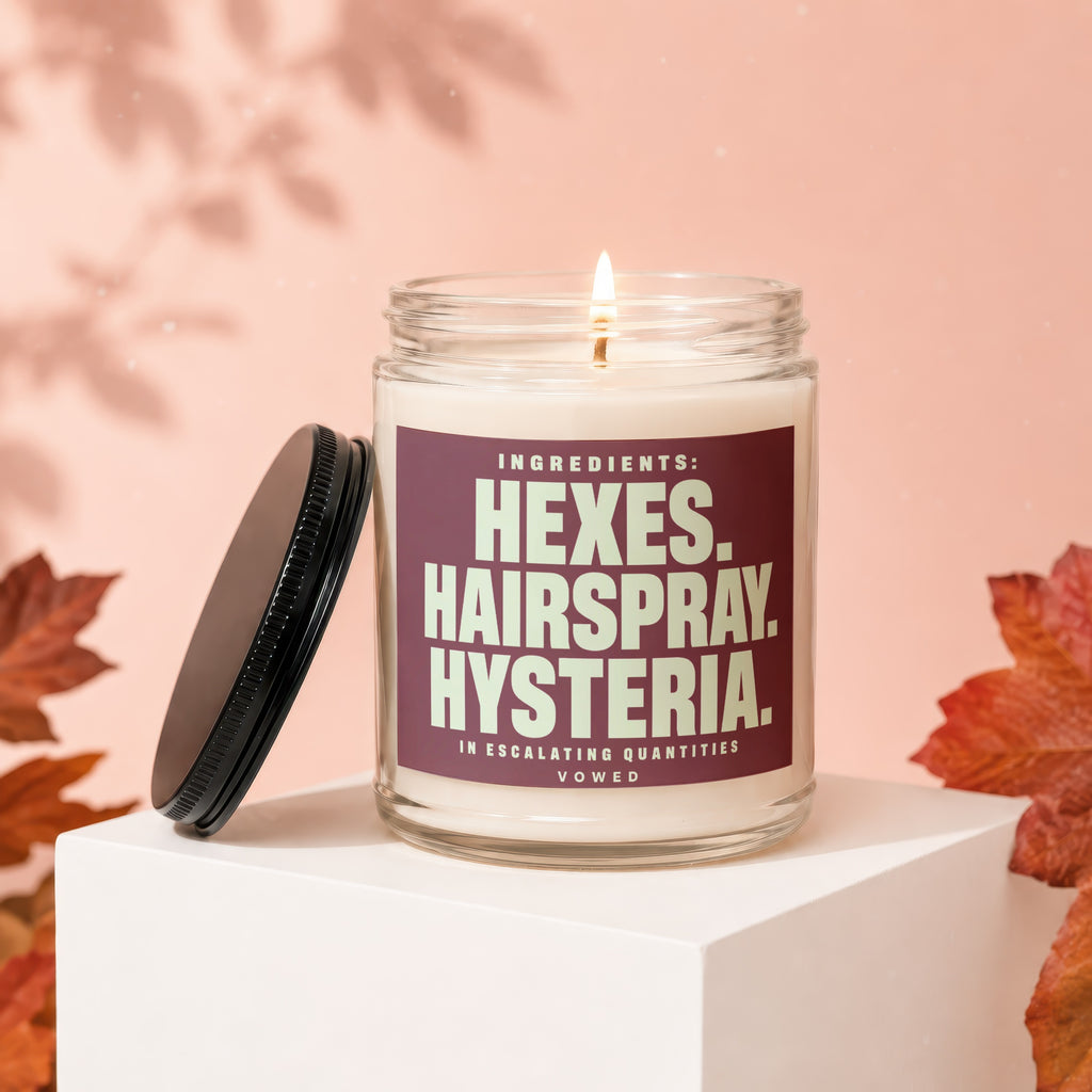 Candle with label "Ingredients: Hexes, Hairspray, Hysteria."