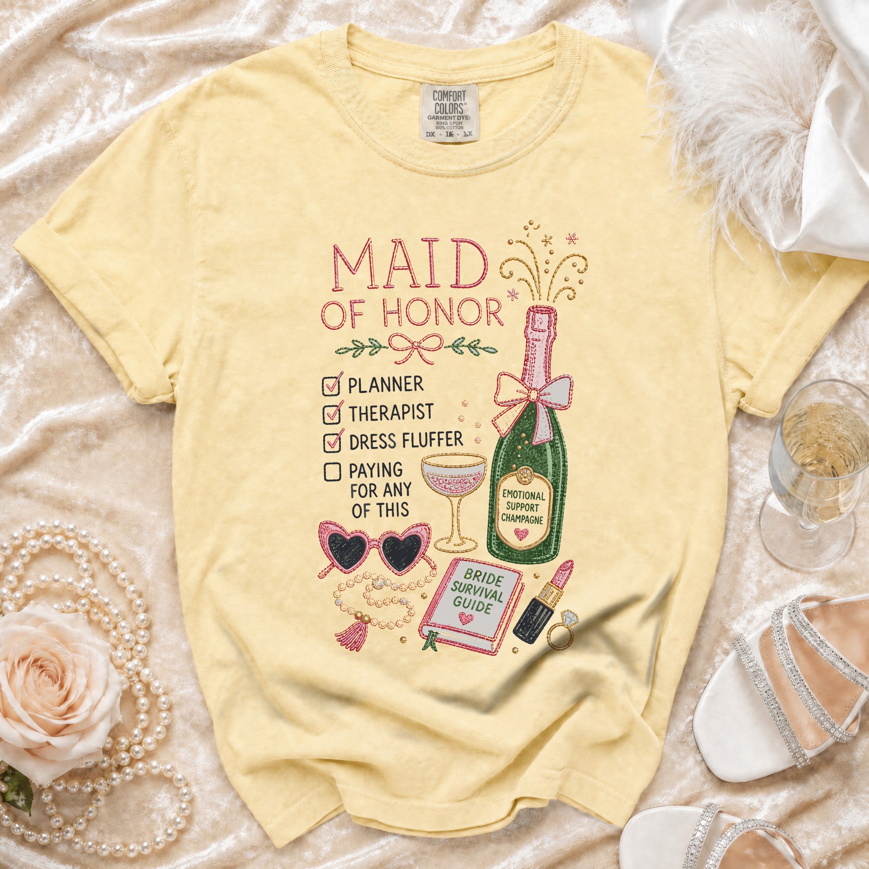 Yellow t-shirt with "Maid of Honor" graphic, checklist, champagne, and accessories.