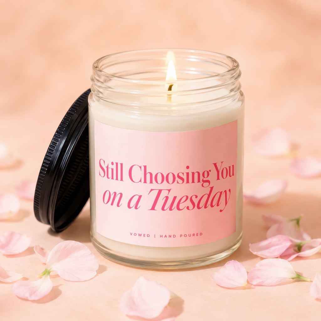 Candle with pink label that reads "Still Choosing You on a Tuesday. Vowed | Hand Poured."