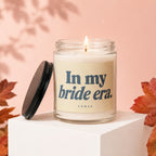 Candle with text "In my bride era." on a light peach background.