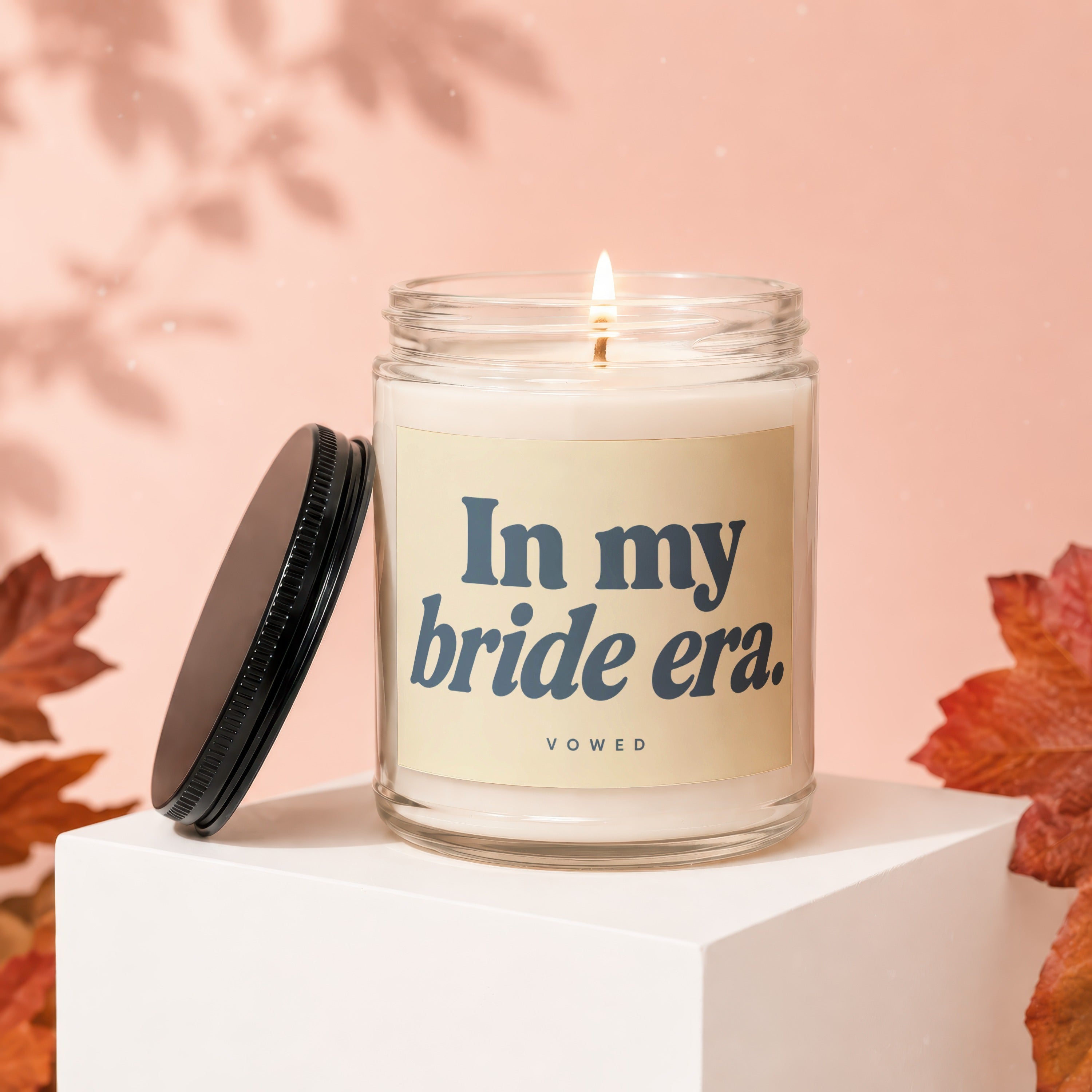 Candle with text "In my bride era." on a light peach background.