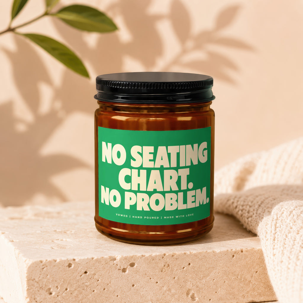 Glass jar candle with green label reading "NO SEATING CHART. NO PROBLEM."