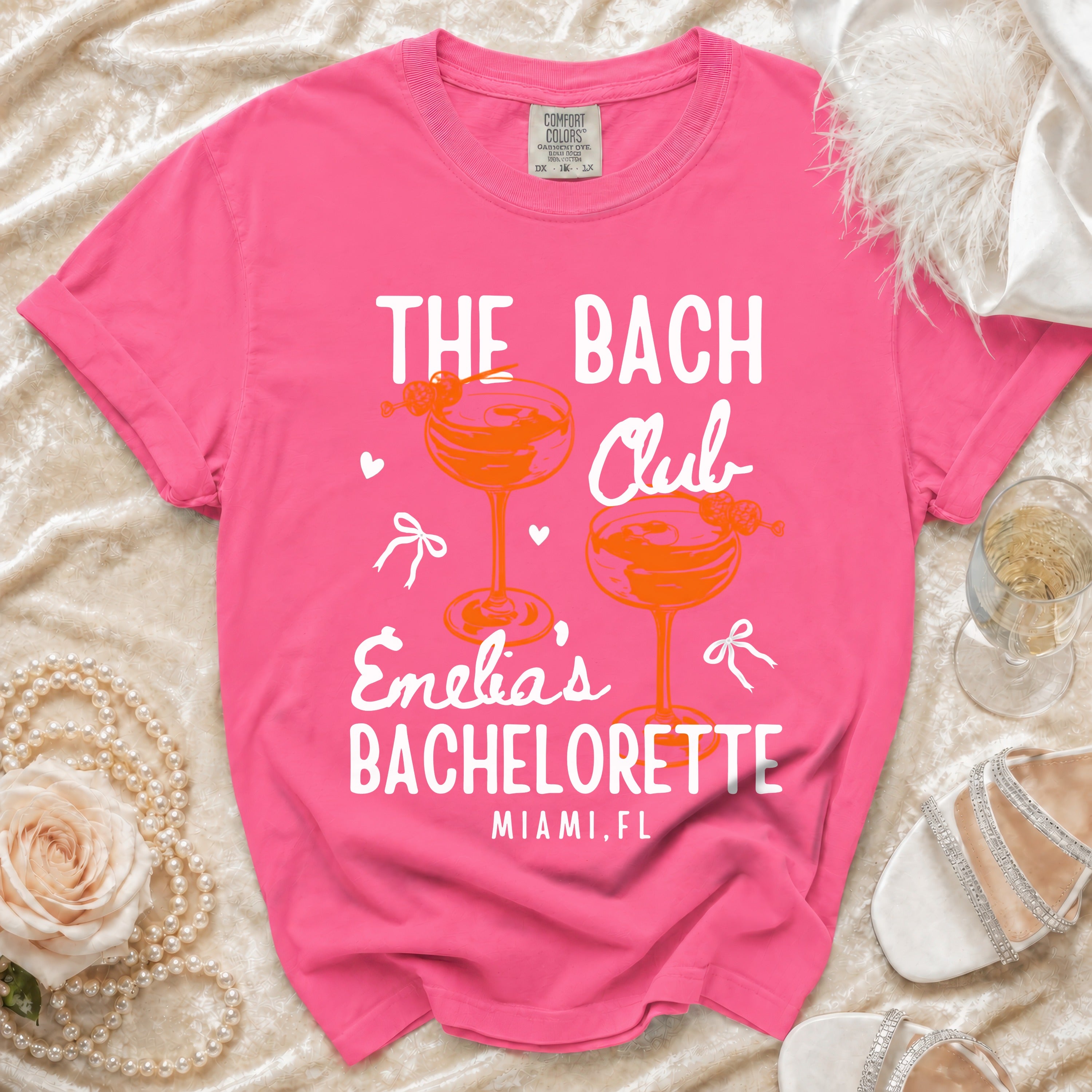 Pink t-shirt with "The Bach Club Emelia's Bachelorette Miami, FL" text.