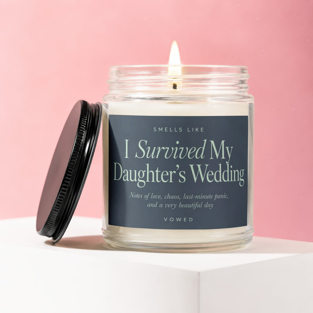 Jar candle with a lit wick, reads "I Survived My Daughter's Wedding."