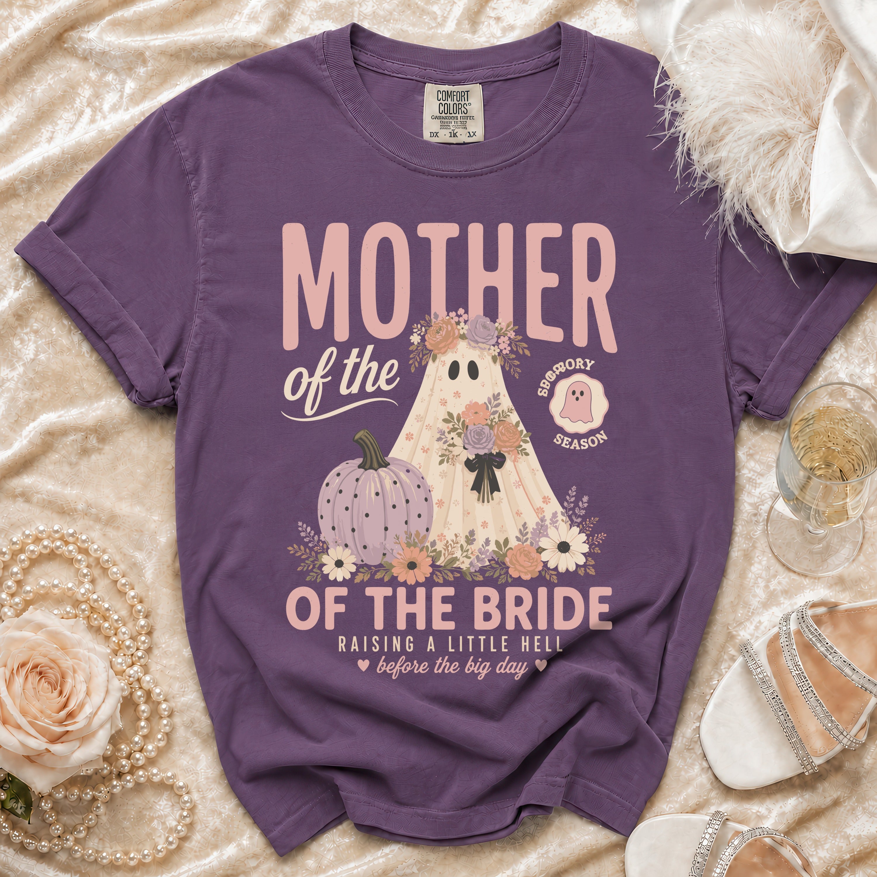 Purple t-shirt with "Mother of the Bride" graphic featuring a ghost, pumpkin, and flowers.