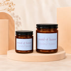 Two amber glass candles labeled "maid of honor" with descriptive text and brand name.
