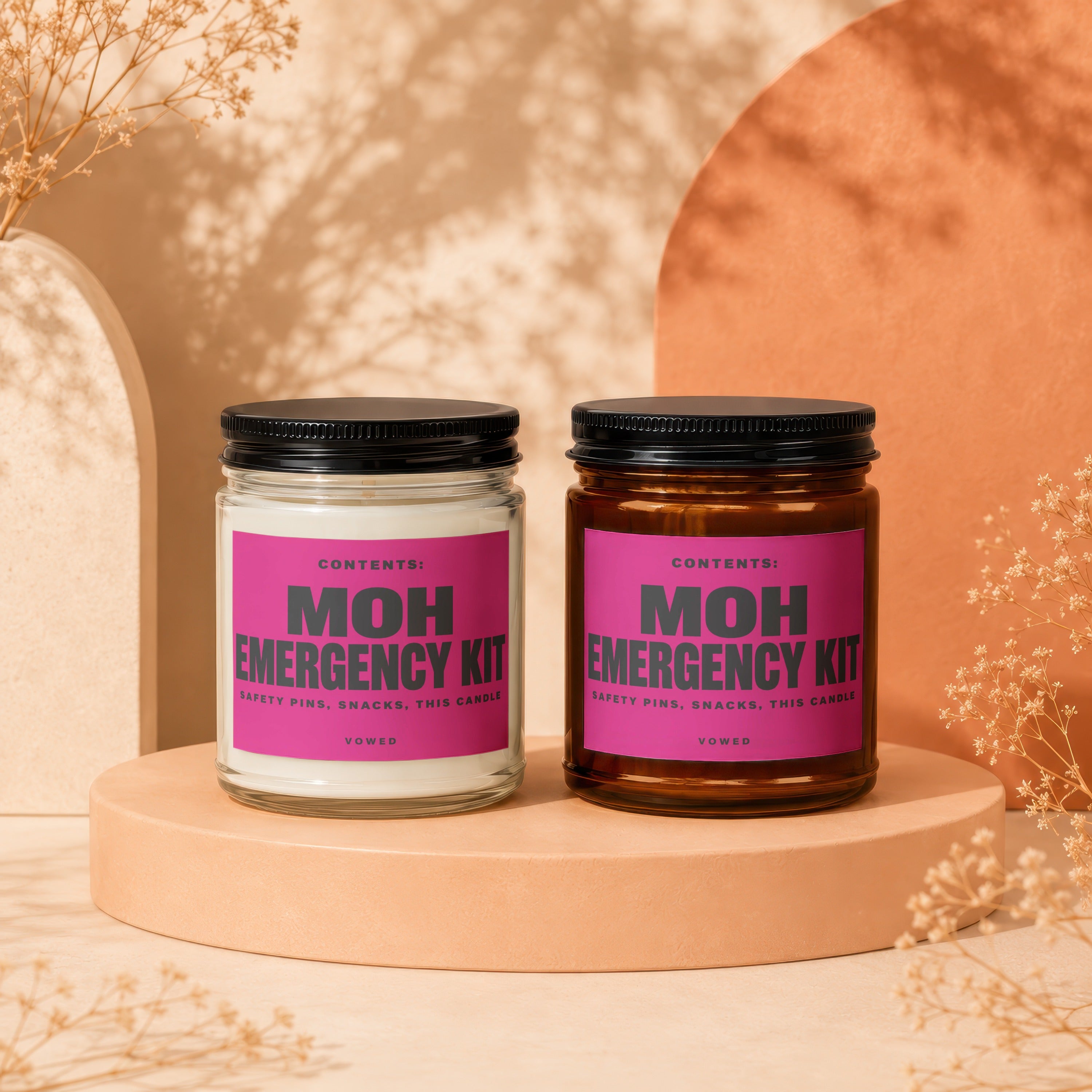 Two candles labeled "MOH EMERGENCY KIT" with text about safety pins and snacks.
