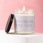 Candle with text "TWO GROOMS, ONE AISLE" on a pink background.