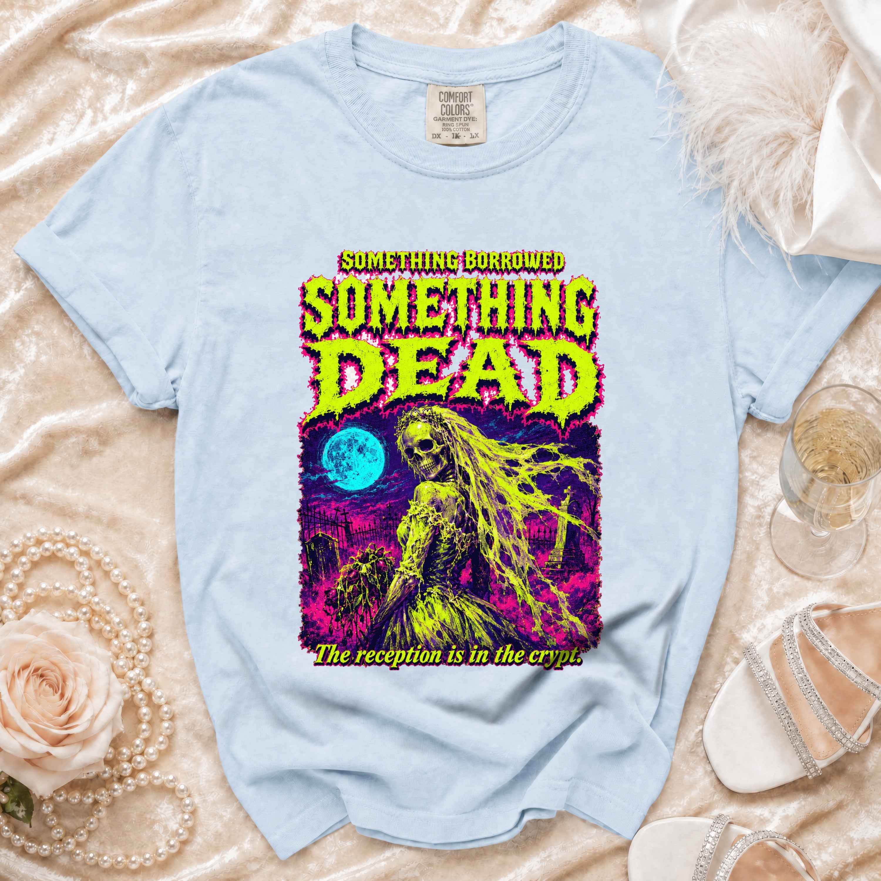 Light blue t-shirt with "Something Borrowed, Something Dead. The reception is in the crypt." graphic.