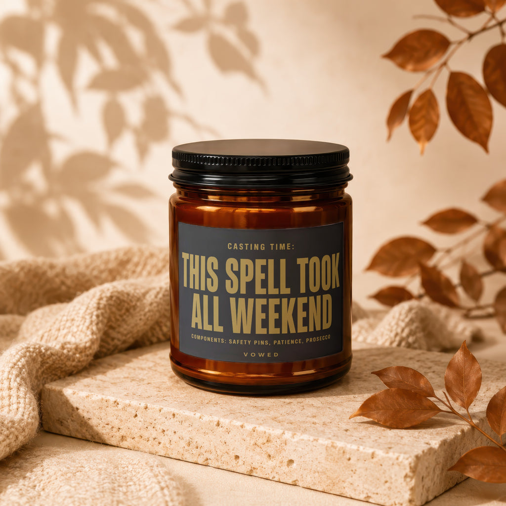 Amber candle with black lid, reads "This Spell Took All Weekend".