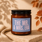 Amber jar candle labeled "The Mr. & Mrs. Era" with "No End Date Scheduled. Vowed."