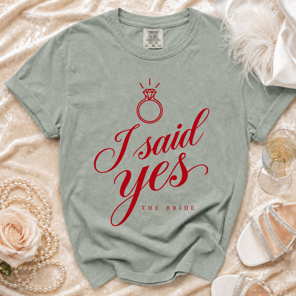 Sage green crewneck t-shirt featuring red script text reading I said yes above The Bride.