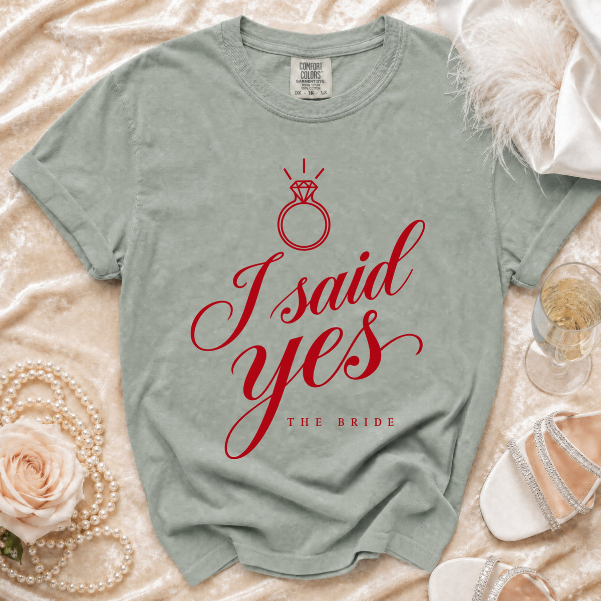 Sage green crewneck t-shirt featuring red script text reading I said yes above The Bride.