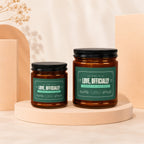 Two amber glass candles with "Love, Officially" labels on a cream and peach background.