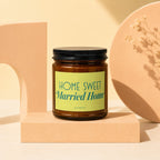 Brown glass candle with black lid and "Home Sweet Married Home" label.