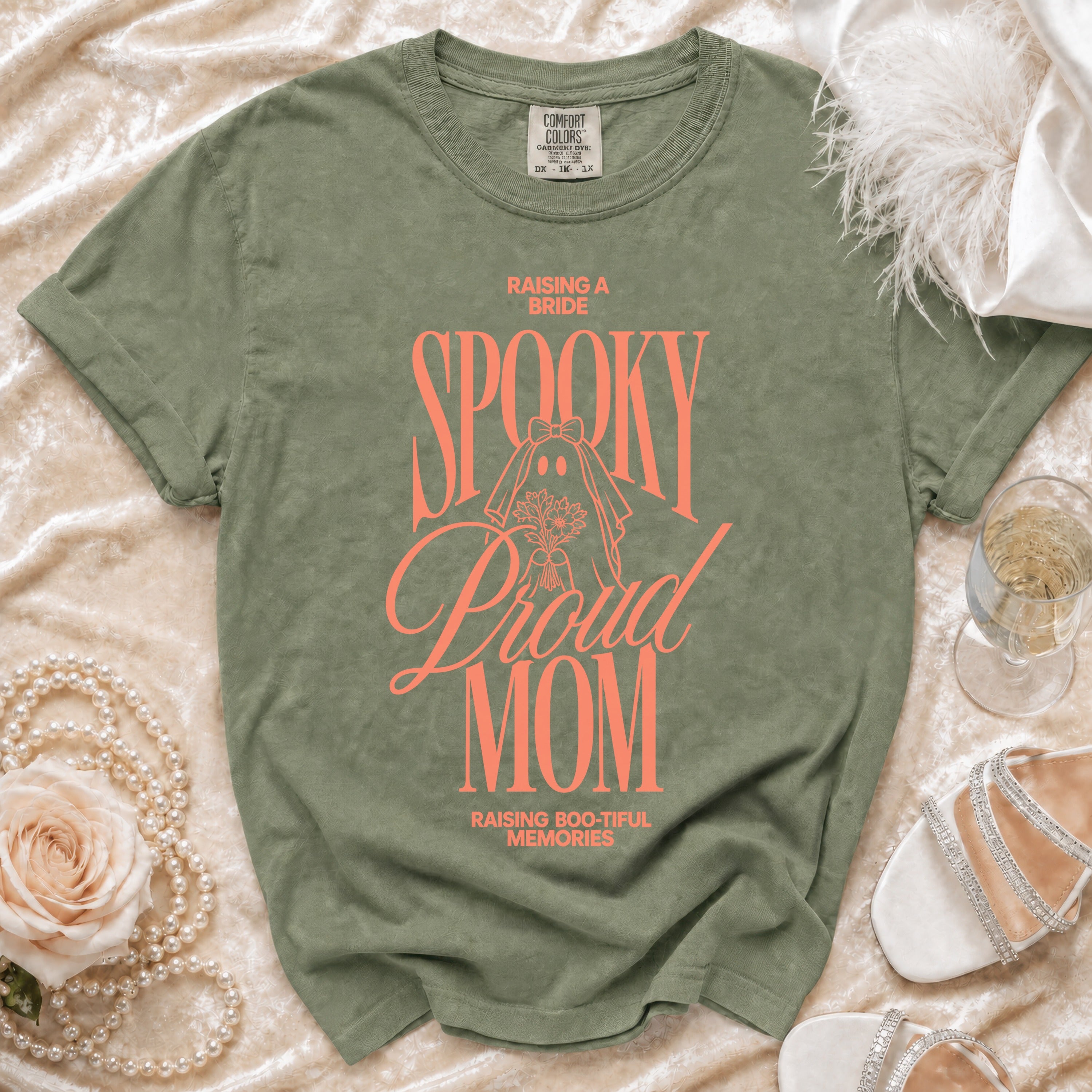 Green t-shirt with "Raising a Bride Spooky Proud Mom" text and ghost graphic.