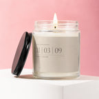 Jar candle with lit wick, black lid, and custom label for Ruth + Caleb anniversary.
