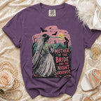 Purple t-shirt featuring a spooky graveyard scene with a bride and the text Mother of the Bride and the Night Survivor.