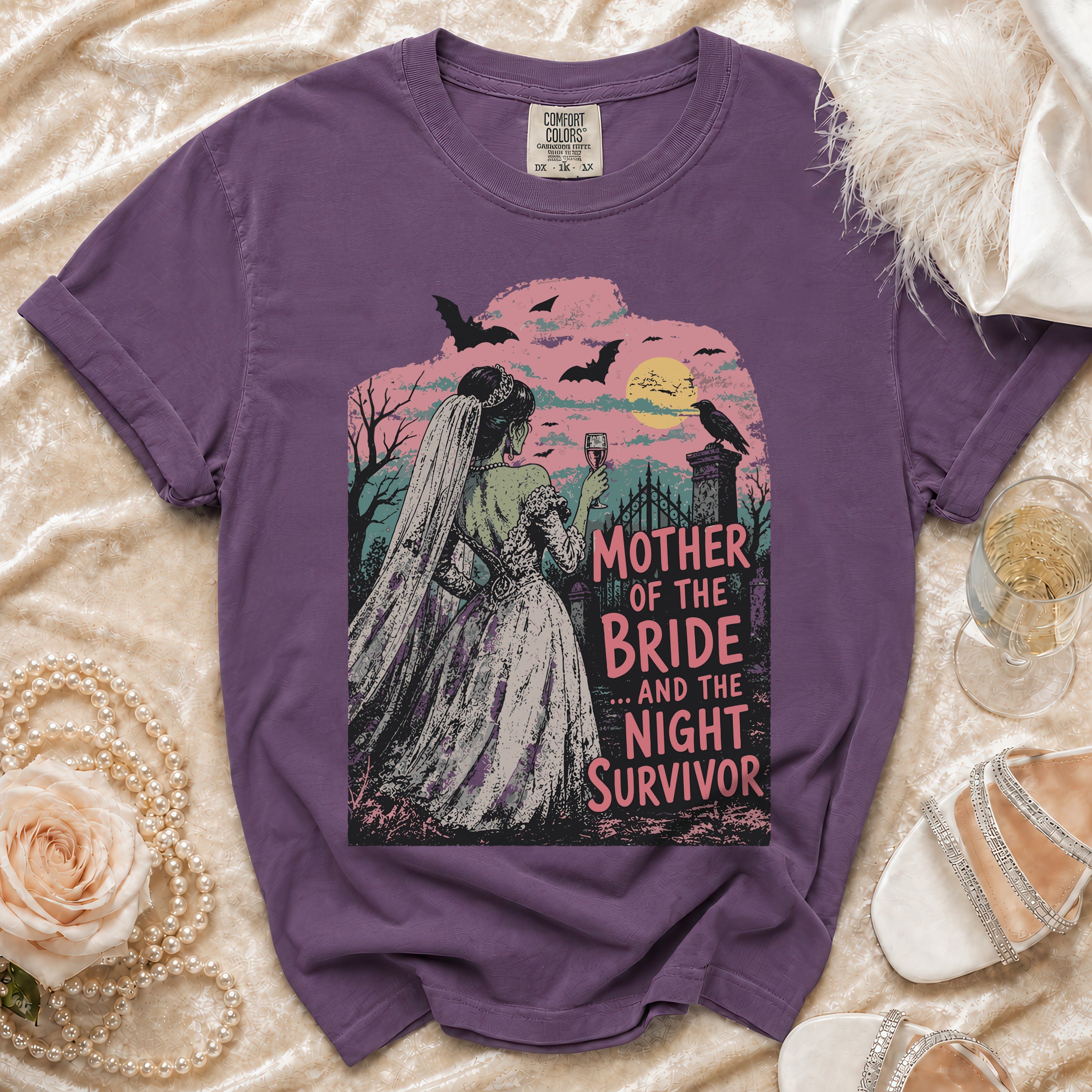 Purple t-shirt featuring a spooky graveyard scene with a bride and the text Mother of the Bride and the Night Survivor.