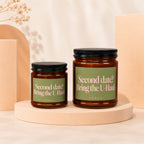Two brown glass candles with green labels reading "Second date? Bring the U-Haul".
