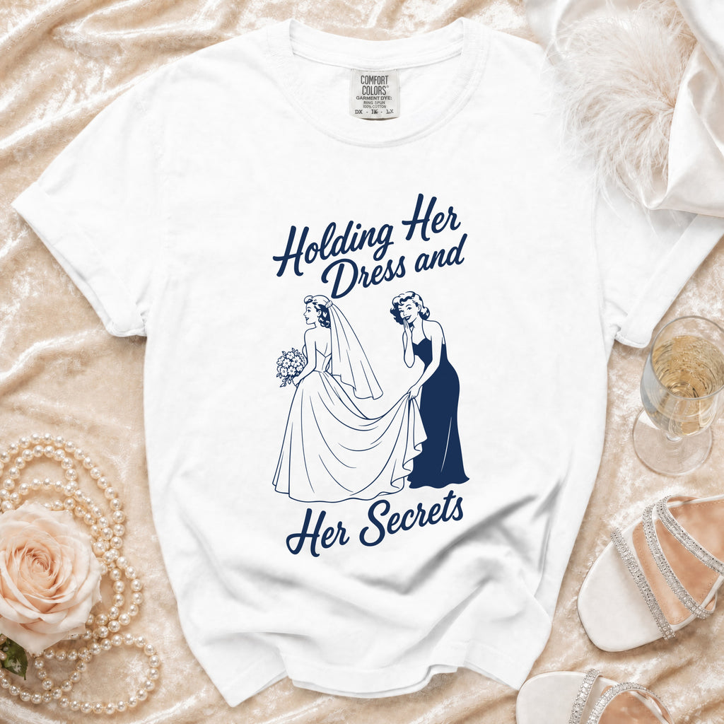 White t-shirt with navy graphic saying "Holding her dress and her secrets".