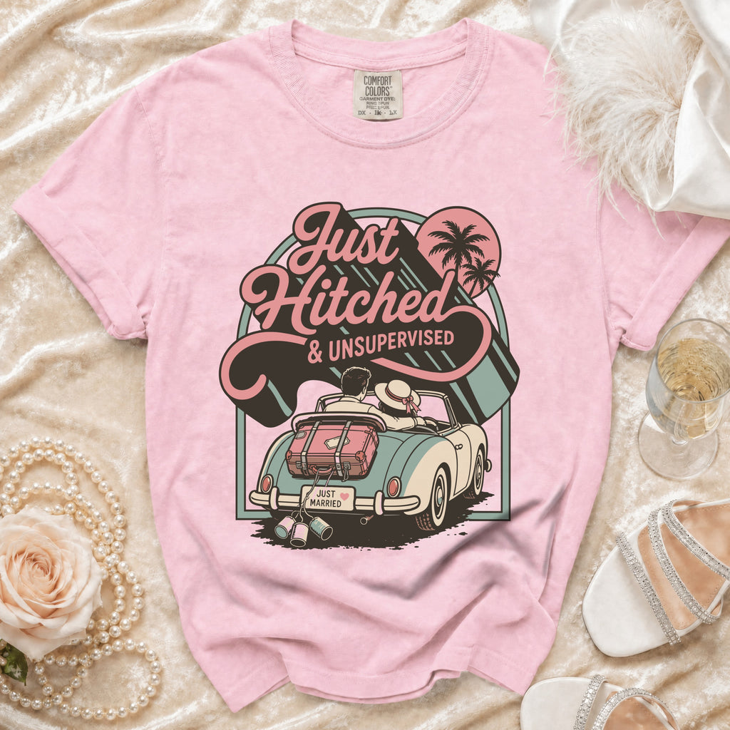 Pink t-shirt with "Just Hitched & Unsupervised" graphic and retro car scene.