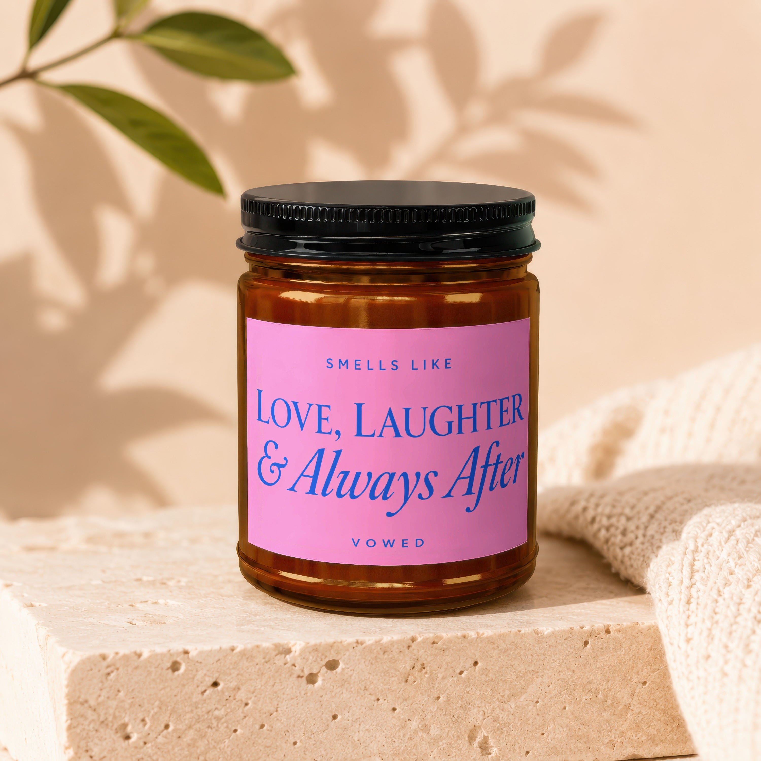 Amber candle with pink label that reads "Smells like Love, Laughter & Always After"