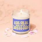 Jar candle with a lit wick, featuring a blue label that says "RIDE OR DIE, NOW WITH A DRESS CODE".