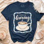Navy t-shirt with "Love is Brewing" text and coffee cup graphic.