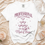 White t-shirt with "Professional Chaos Coordinator Maid of Honor" text and champagne glass pyramid graphic.