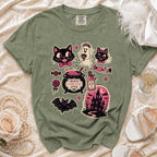 Green t-shirt with Halloween graphics including cats, a ghost, bat, and haunted house.