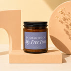 Amber jar candle with "In Memory Of My Free Time" text on a purple label.