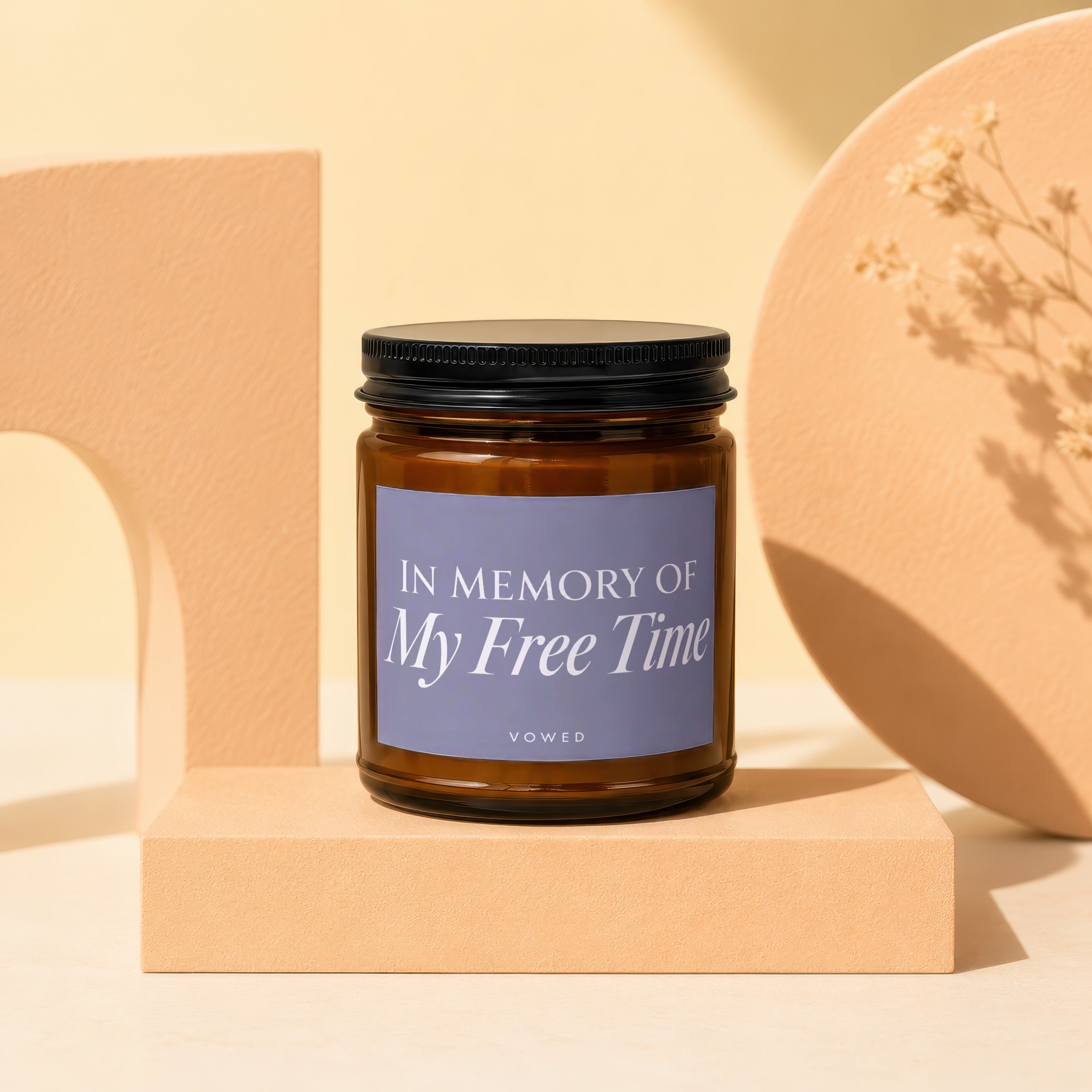 Amber jar candle with "In Memory Of My Free Time" text on a purple label.