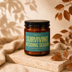 Amber jar candle labeled "SURVIVING WEDDING SEASON" with text "SEVEN INVITATIONS. ONE SURVIVOR."
