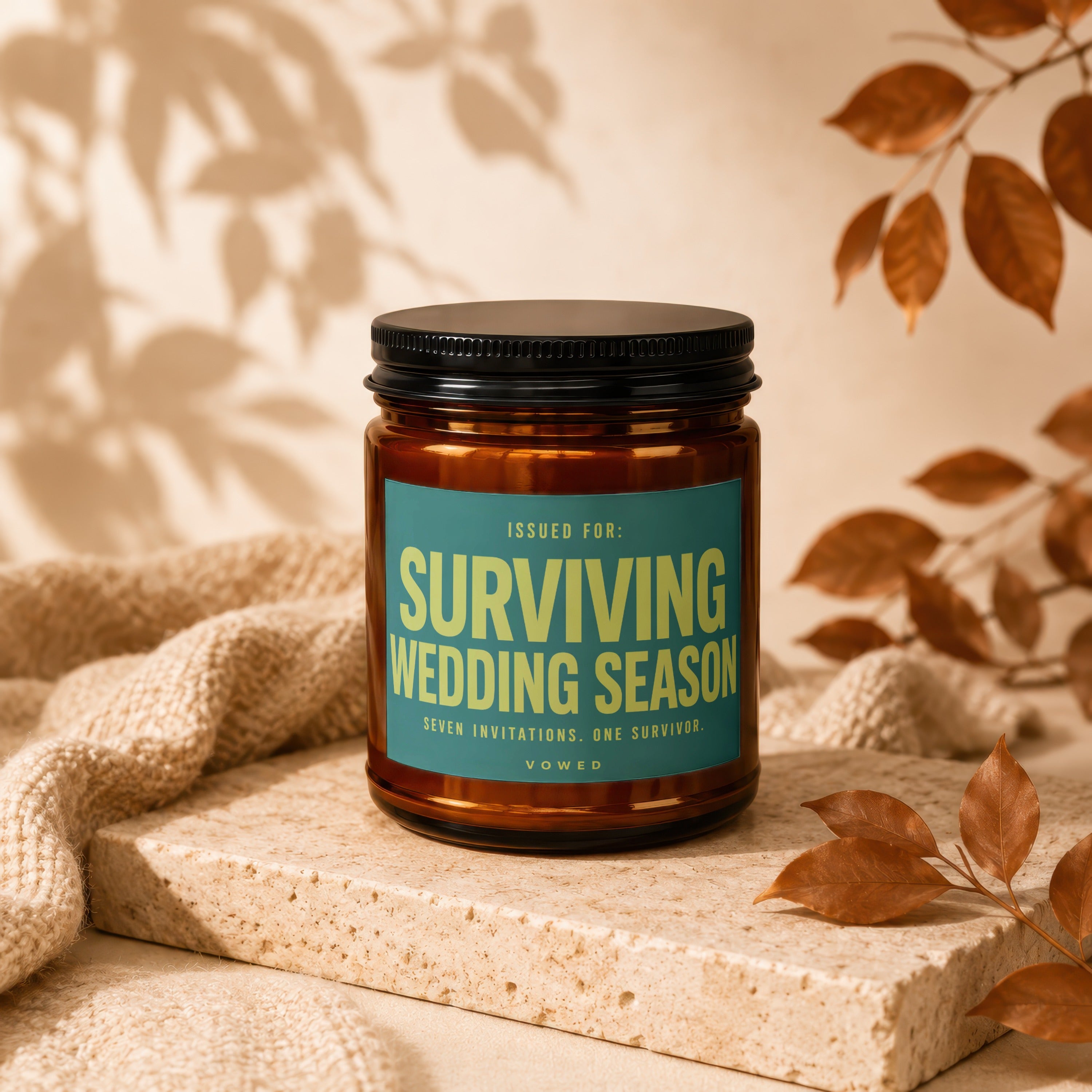 Amber jar candle labeled "SURVIVING WEDDING SEASON" with text "SEVEN INVITATIONS. ONE SURVIVOR."
