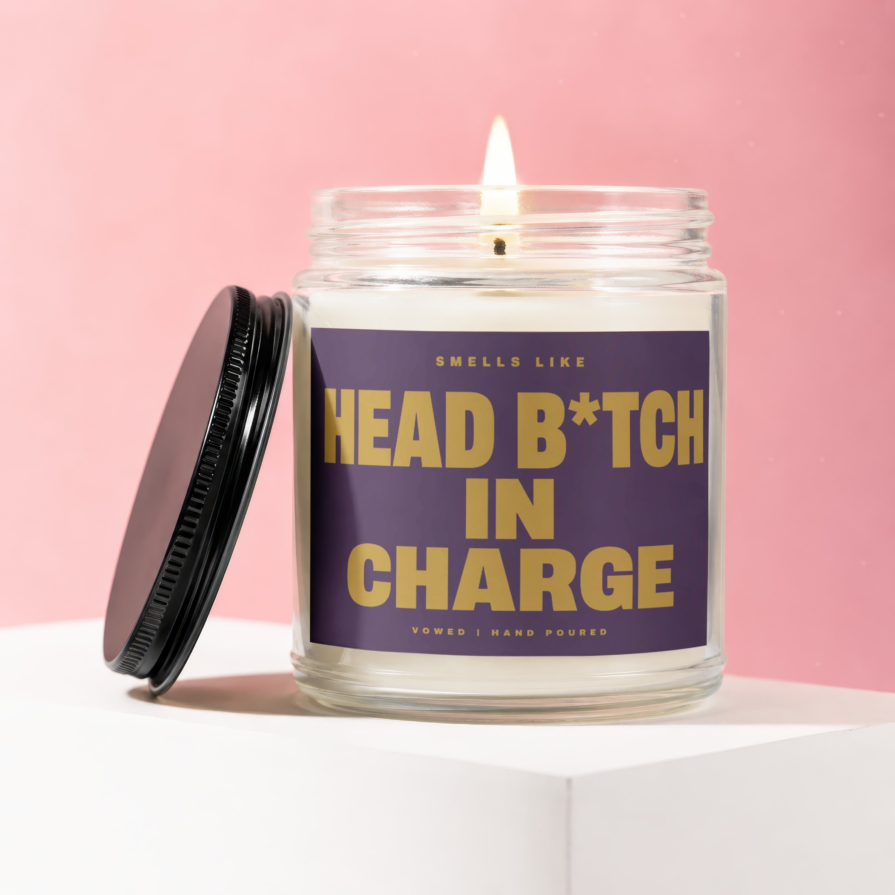Candle with "Smells like head b*tch in charge" text and lit wick.