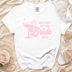 White t-shirt with pink "Mother of the Bride Era" text and a champagne glass graphic.