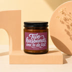 Candle with text "Two husbands, one to-do list" on label, VOWED.
