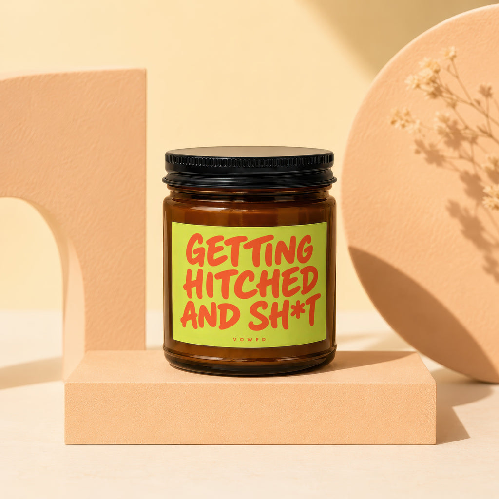Amber jar candle with a lime green label that reads "GETTING HITCHED AND SH*T VO WED".