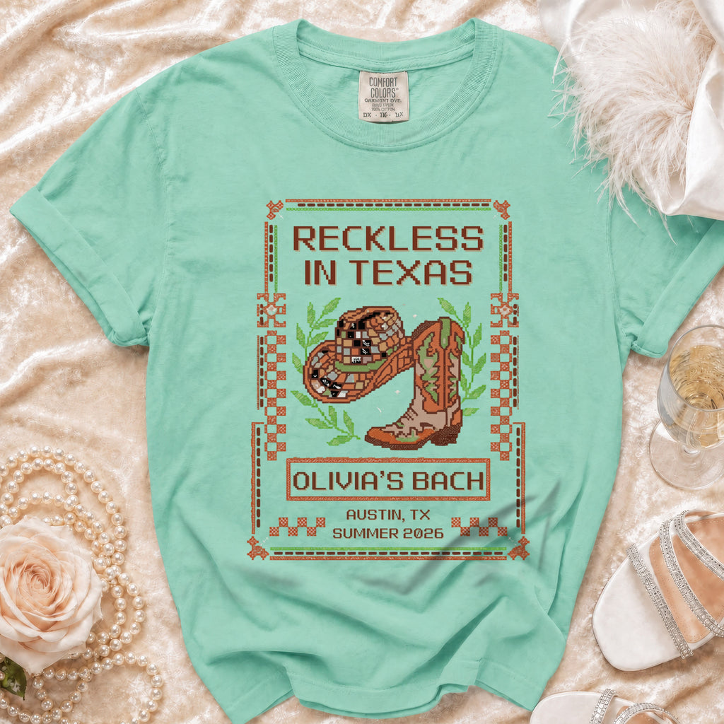 Green t-shirt with "Reckless in Texas" and cowboy boot graphic.