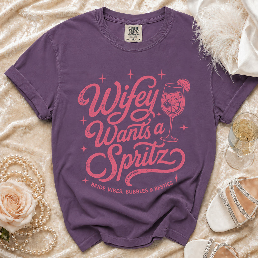 Purple tee with pink "Wifey Wants a Spritz" graphic and "Bride Vibes, Bubbles & Besties" text.